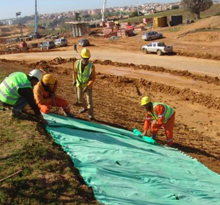Pro-grass biotextile fabric being laid across a verge Pro-grass biotextile fabric being laid across a verge