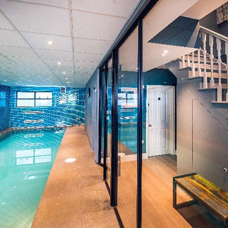 Gymnasium and pool in London basement divided in style