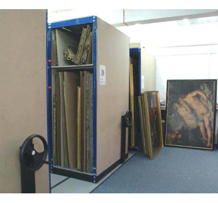 Picture frames are protected by Linoleum applied to shelving to provide cushioning whilst allowing paintings to be slid into each location